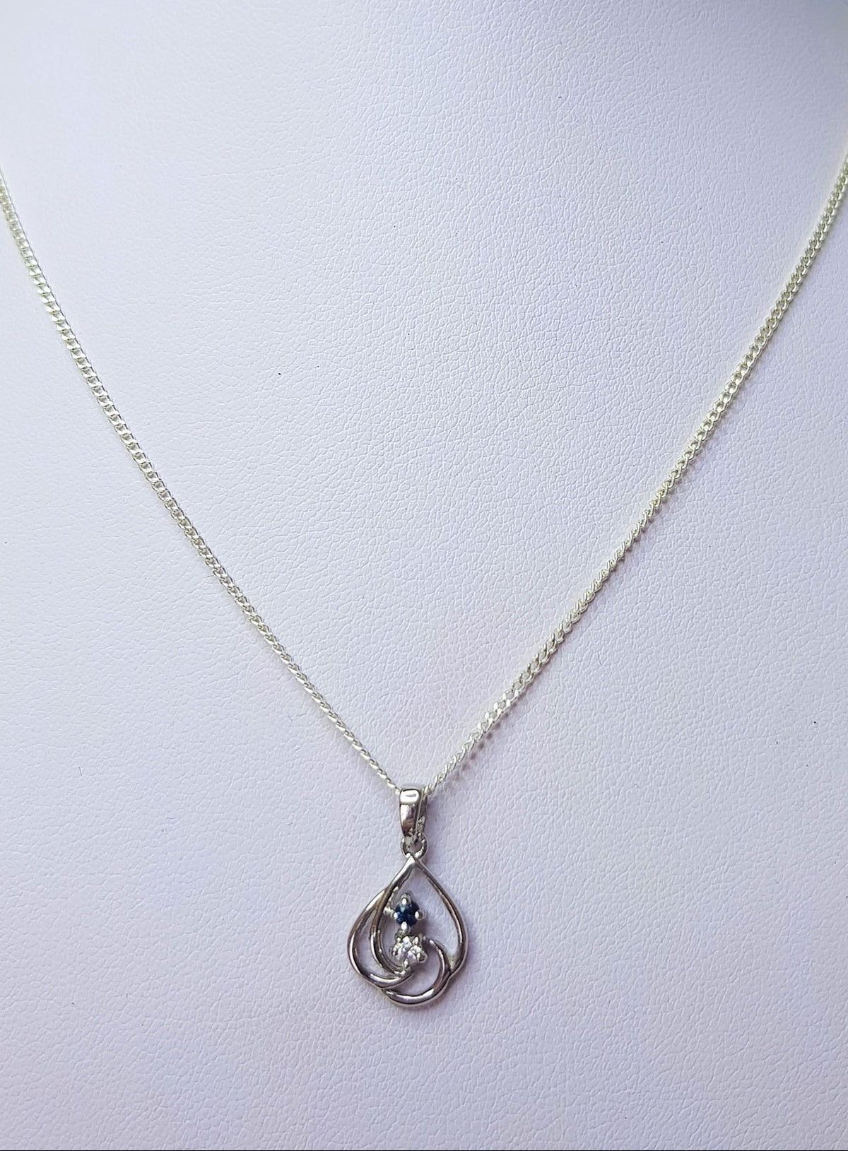 Sapphire and cubic zirconia sterling silver swirl pendant necklace on a mannequin