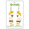 A pair of novelty cockatoo earrings on a white backing card. The earrings feature a white cockatoo with bright yellow crest feathers and brown details, hanging from silver hooks.